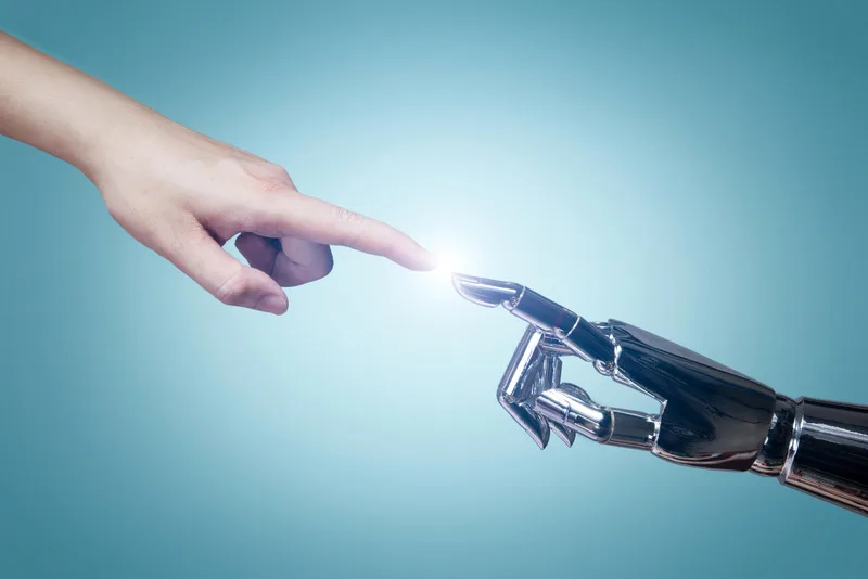 A human finger touching a robotic finger, symbolizing the synergy between humans and artificial intelligence.