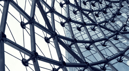 Close-up view of modern architectural steel and glass structure, representing interconnected systems and organizational frameworks.