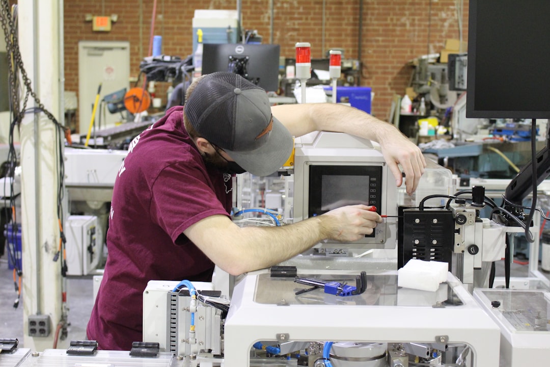 Industrial technician working with manufacturing equipment and monitoring systems