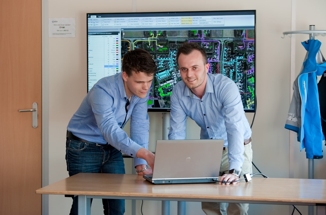 Professional reviewing monitoring data on a laptop screen representing continuous AI system oversight and compliance tracking
