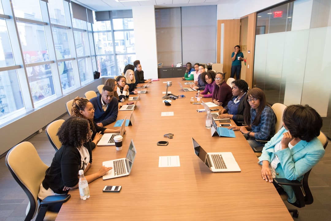 Enterprise team collaborating around a table with laptops, representing the cross-functional coordination required for AI accountability governance